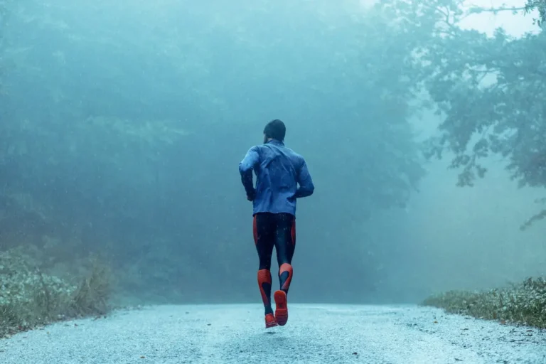 Ein Triathlet, der im Regen laufen geht.