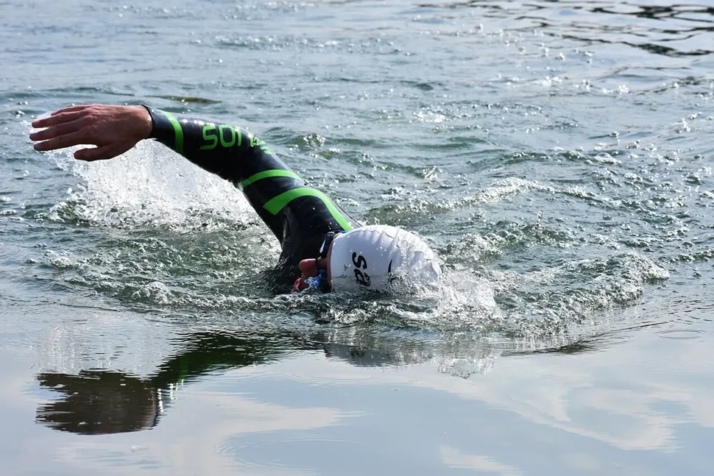 Triathlet, der im offenen Gewässer schwimmt.